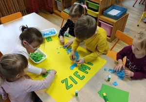 Dzieci wykonują plakat z okazji Dnia Ziemi.